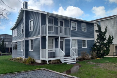 Inspiration for a large timeless blue two-story wood exterior home remodel in Other with a shingle roof
