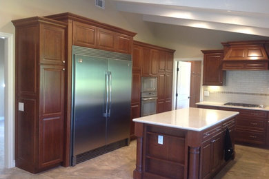 Eat-in kitchen - mid-sized contemporary l-shaped ceramic tile eat-in kitchen idea in San Diego with recessed-panel cabinets, dark wood cabinets, granite countertops, beige backsplash, ceramic backsplash, stainless steel appliances and an island