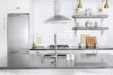 Example of an eclectic kitchen design in Vancouver with an undermount sink, open cabinets, gray cabinets, quartz countertops, white backsplash, porcelain backsplash, stainless steel appliances and an island