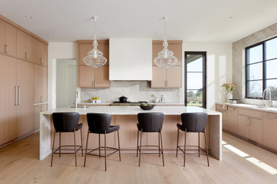 Transitional l-shaped light wood floor eat-in kitchen photo in San Francisco with an undermount sink, flat-panel cabinets, light wood cabinets, quartzite countertops, beige backsplash, stone slab backsplash, paneled appliances, an island and beige countertops