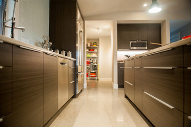 Inspiration for a modern galley open concept kitchen remodel with flat-panel cabinets, stainless steel appliances and an island