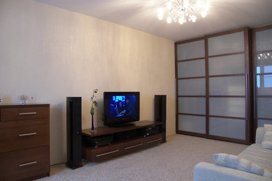 Идея дизайна: большая изолированная гостиная комната в современном стиле с бежевыми стенами, ковровым покрытием, отдельно стоящим телевизором и бежевым полом