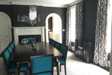 Example of a large trendy dark wood floor and brown floor enclosed dining room design in New York with gray walls, a standard fireplace and a wood fireplace surround