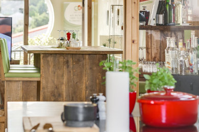 Großes, Offenes Rustikales Wohnzimmer ohne Kamin mit Hausbar, grauer Wandfarbe, Teppichboden, freistehendem TV und grauem Boden in Frankfurt am Main