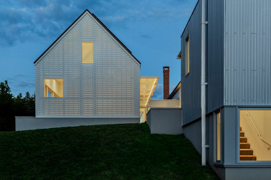 Inspiration for a contemporary white two-story metal gable roof remodel in Other with a metal roof and a gray roof