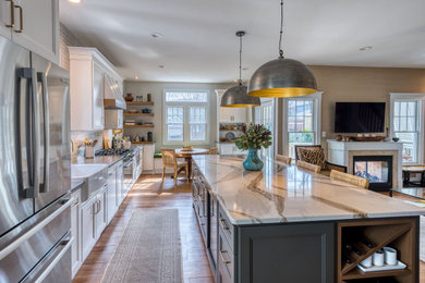 Inspiration for a mid-sized transitional kitchen remodel in DC Metro with a farmhouse sink, shaker cabinets, white cabinets, quartz countertops, ceramic backsplash, stainless steel appliances and an island