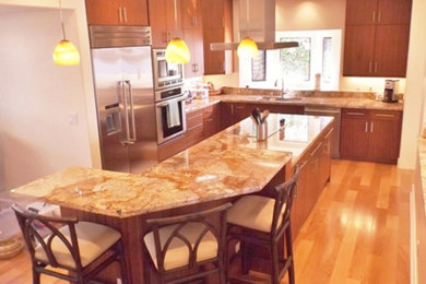 Eat-in kitchen - mid-sized traditional l-shaped medium tone wood floor and brown floor eat-in kitchen idea in Hawaii with an undermount sink, flat-panel cabinets, medium tone wood cabinets, granite countertops, stainless steel appliances and an island