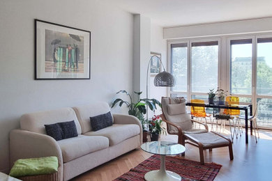 Idee per un grande soggiorno moderno aperto con pareti bianche, parquet chiaro e TV a parete