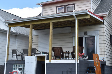 This is an example of a modern back porch design in Other with a roof extension.