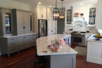 Inspiration for a large transitional l-shaped eat-in kitchen in Indianapolis with an undermount sink, recessed-panel cabinets, white cabinets, quartz benchtops, white splashback, subway tile splashback, stainless steel appliances, medium hardwood floors and with island.