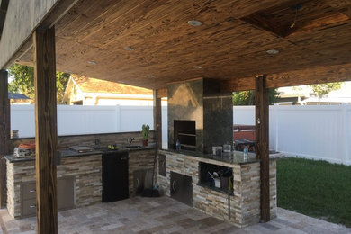 This is an example of a mid-sized transitional backyard patio in Tampa with a roof extension.
