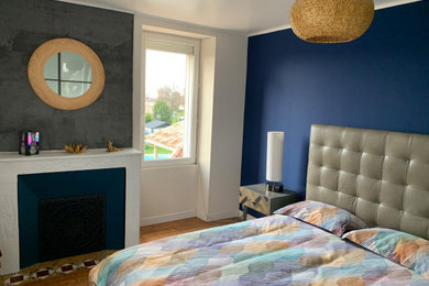 ボルドーにある中くらいなモダンスタイルのおしゃれな主寝室 (青い壁、淡色無垢フローリング、標準型暖炉) のインテリア