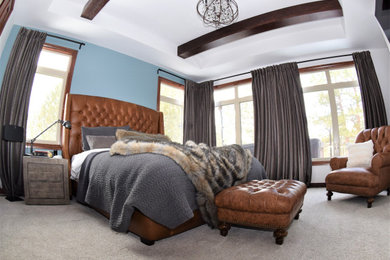 Large country master bedroom in Denver with grey walls, carpet, beige floor and exposed beam.