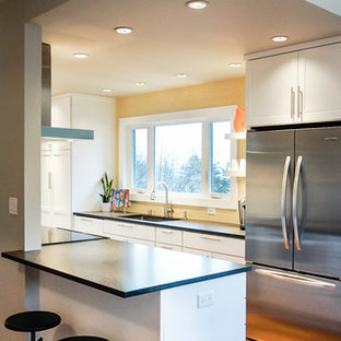 На фото: маленькие параллельные кухни-гостиные в стиле ретро с врезной раковиной, фасадами в стиле шейкер, белыми фасадами, столешницей из кварцевого композита, желтым фартуком, фартуком из керамической плитки, техникой из нержавеющей стали, полом из бамбука и полуостровом