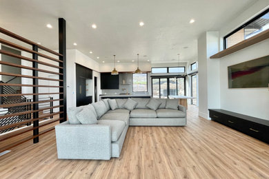 Inspiration for a mid-sized modern open concept medium tone wood floor living room remodel in Salt Lake City with white walls and a wall-mounted tv