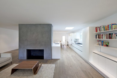 Mid-sized modern open concept living room in Los Angeles with white walls, medium hardwood floors, a standard fireplace and a concrete fireplace surround.