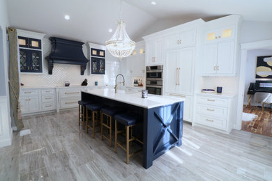 Mid-sized farmhouse l-shaped porcelain tile, gray floor and vaulted ceiling eat-in kitchen photo in Boston with a farmhouse sink, beaded inset cabinets, blue cabinets, quartz countertops, white backsplash, porcelain backsplash, paneled appliances, an island and white countertops