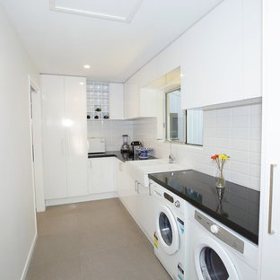 This is an example of a small modern single-wall kitchen pantry in Sunshine Coast with a double-bowl sink, flat-panel cabinets, white cabinets, quartz benchtops, white splashback, ceramic splashback, white appliances and ceramic floors.