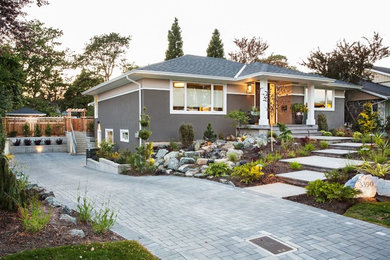 Inspiration for a mid-sized transitional gray two-story stucco house exterior remodel in Vancouver with a hip roof and a shingle roof