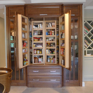 Cette photo montre une arrière-cuisine tendance en U avec un plan de travail en stéatite, des portes de placard en bois brun, une crédence en carreau de verre et un électroménager en acier inoxydable.