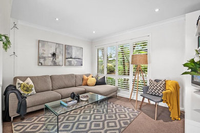 Scandinavian living room in Sydney with white walls, carpet and beige floor.