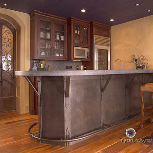 На фото: параллельные домашние бары среднего размера в стиле фьюжн с барной стойкой, фасадами в стиле шейкер, фасадами цвета темного дерева, столешницей из талькохлорита и паркетным полом среднего тона