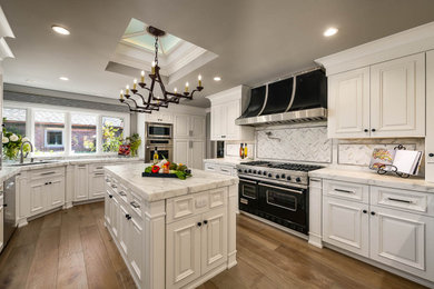 Example of a transitional kitchen design in San Francisco with marble countertops and an island