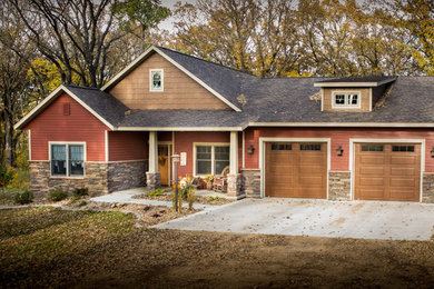 Example of a classic red one-story vinyl exterior home design in Other with a shingle roof
