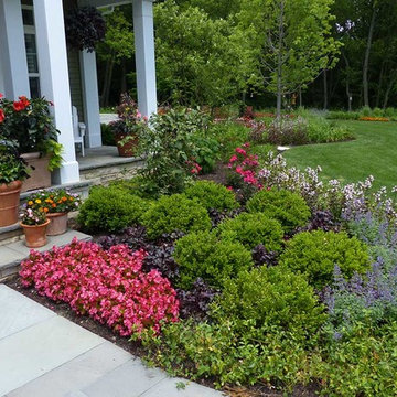 Generous plantings line the bluestone walkway with season-long color.