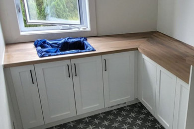 Example of a country laundry room design in Miami with shaker cabinets, white cabinets, wood countertops, a side-by-side washer/dryer and brown countertops