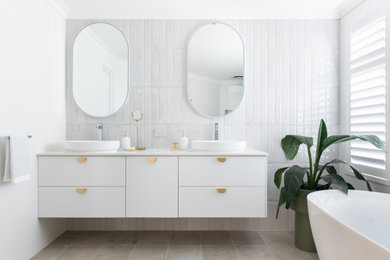 This is an example of a modern master bathroom in Perth with white cabinets, a freestanding tub, an open shower, ceramic tile, porcelain floors, a vessel sink, engineered quartz benchtops, an open shower, white benchtops, a niche, a double vanity and a floating vanity.