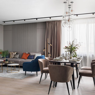 На фото: большая гостиная-столовая в современном стиле с серыми стенами, светлым паркетным полом и бежевым полом с