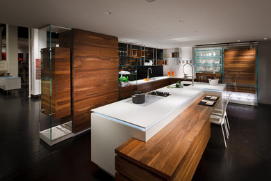 Inspiration for a large contemporary galley open plan kitchen in New York with an undermount sink, flat-panel cabinets, medium wood cabinets, panelled appliances, with island, black floor, quartz benchtops and dark hardwood floors.