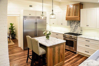 Kitchen - transitional u-shaped medium tone wood floor kitchen idea in Charleston with a farmhouse sink, shaker cabinets, white cabinets, marble countertops, stainless steel appliances and an island