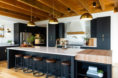 Inspiration for a large open concept kitchen remodel in New York with a farmhouse sink, black cabinets and an island