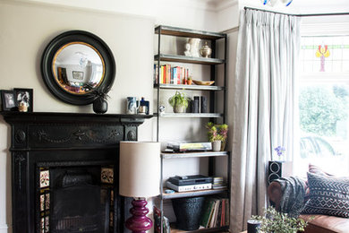 Living room - mid-sized traditional formal and enclosed medium tone wood floor and brown floor living room idea in London with gray walls, a standard fireplace and a tile fireplace