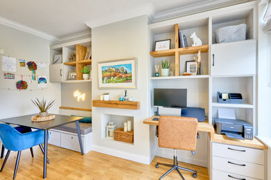 Photo of a medium sized modern games room with a game room, grey walls, laminate floors, a wooden fireplace surround, no tv, brown floors and feature lighting.