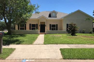 Inspiration for a mid-sized southwestern beige two-story adobe house exterior remodel in Houston with a hip roof and a shingle roof
