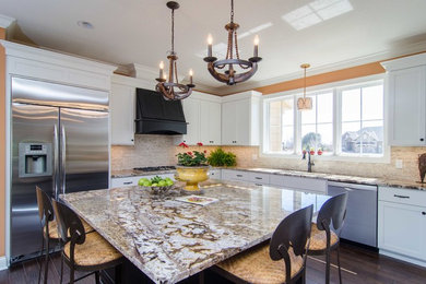 Example of a classic l-shaped dark wood floor kitchen design in Minneapolis with recessed-panel cabinets, white cabinets, granite countertops, beige backsplash, stainless steel appliances and an island