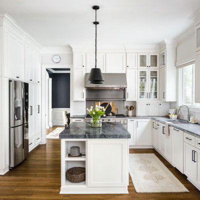 Example of a mid-sized transitional l-shaped medium tone wood floor and brown floor eat-in kitchen design in Charlotte with an undermount sink, shaker cabinets, white cabinets, quartzite countertops, gray backsplash, porcelain backsplash, stainless steel appliances, an island and black countertops