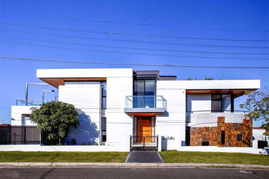Photo of a mid-sized contemporary two-storey concrete white house exterior in Sydney with a flat roof.