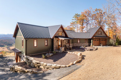 Mountain style green two-story mixed siding and board and batten exterior home photo in Other with a metal roof and a brown roof