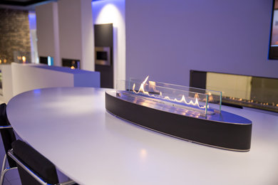 Design ideas for a contemporary dining room in Sussex with a ribbon fireplace.