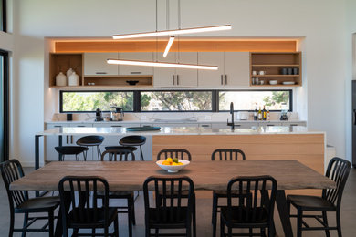 Kitchen/dining room combo - contemporary gray floor kitchen/dining room combo idea in Austin with white walls