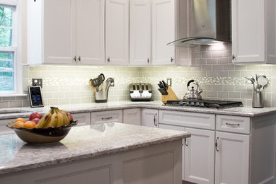 Eat-in kitchen - mid-sized transitional u-shaped dark wood floor eat-in kitchen idea in Baltimore with a single-bowl sink, flat-panel cabinets, white cabinets, quartz countertops, gray backsplash, subway tile backsplash, stainless steel appliances and an island
