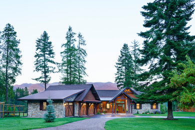 Rustic gray one-story stone exterior home idea in Other with a shingle roof and a brown roof