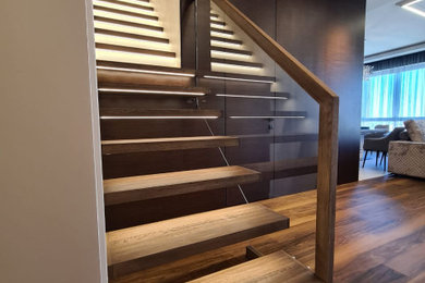 Ejemplo de escalera recta actual de tamaño medio con escalones de madera, contrahuellas de madera y barandilla de vidrio