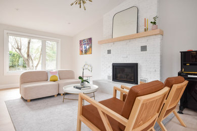 Example of a mid-sized trendy formal and open concept light wood floor and beige floor living room design in Ottawa with white walls, a standard fireplace, a brick fireplace and a media wall