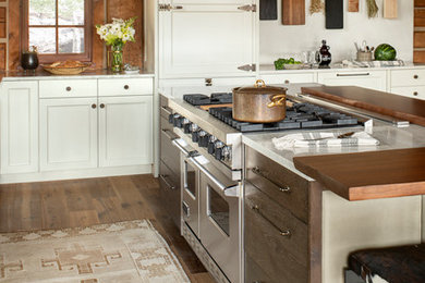 Example of a large classic u-shaped medium tone wood floor open concept kitchen design in Denver with a farmhouse sink, shaker cabinets, white cabinets, quartzite countertops, stainless steel appliances, an island and white countertops