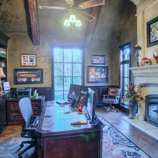 Inspiration for a large country study room in Oklahoma City with grey walls, medium hardwood floors, a standard fireplace, a concrete fireplace surround, a freestanding desk and brown floor.